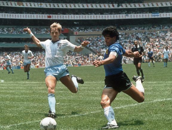 Argentinian forward Diego Maradona gets ready to cross the ball under pressure from English defender Gary Stevens during the World Cup quarterfinal soccer match between Argentina and England on June 1986. 