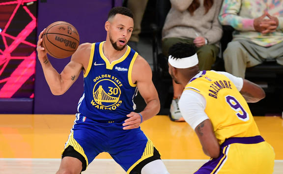 Stephen Curry of the Golden State Warriors (left) tries to get past Kent Bazemore of the Los Angeles Lakers during their NBA season opener on Tuesday.