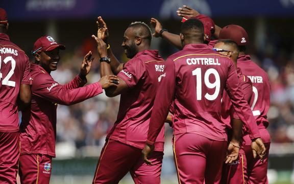 Andre Russell is congratulated by West Indies teammates.