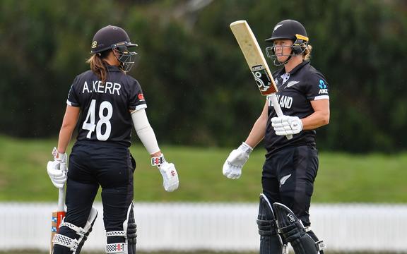 Amelia Kerr congratulates Sophie Devine of New Zealand on reaching 150 runs during the ICC Womens World Cup warm up cricket match against Australia, 2022.