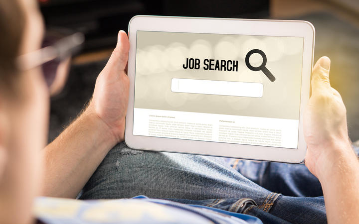 Jobs Man trying to find work with online job search engine on tablet. 