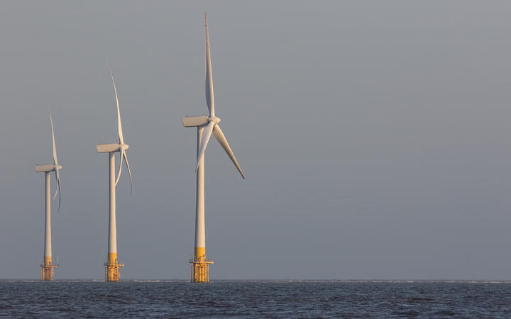 Offshore wind turbines. Wind farm on the sea horizon. Clean energy. Profile of three massive sustainable resource power generation turbines.