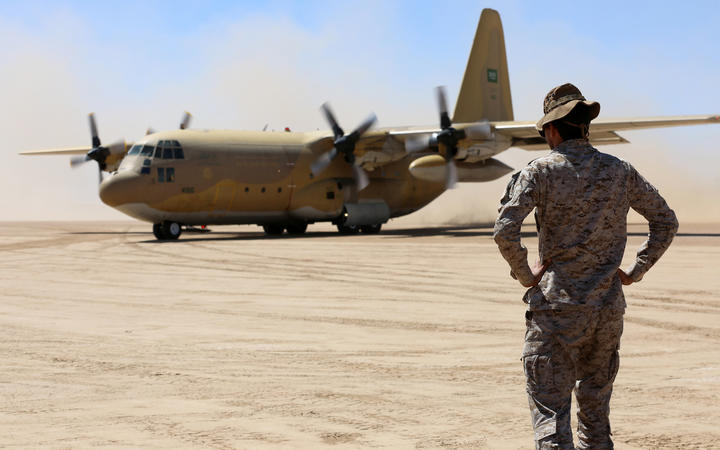 Saudi soldiers stand guard as a Saudi air force cargo plane carrying aid lands at an airfield in Yemen's Marib on 8 February 2018