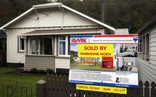 Sold sign in front of house.