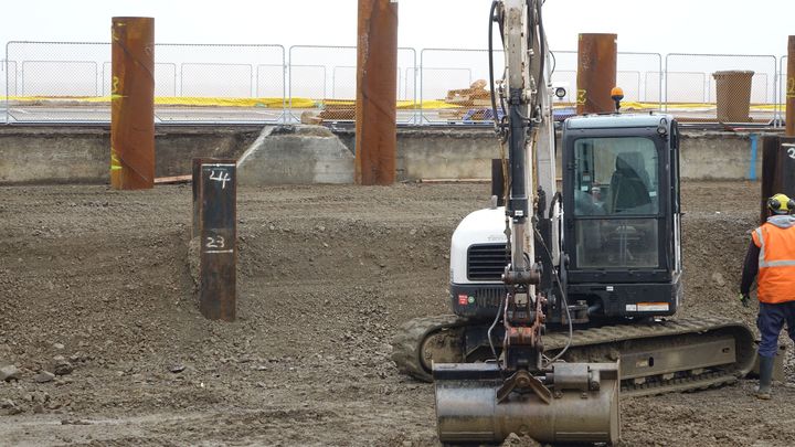 Contractors are installing piles to strengthen the soil.