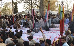 Pakistani mourners gather around the coffins of blast victims during a protest following the powerful bomb explosion near a market in Parachinar.