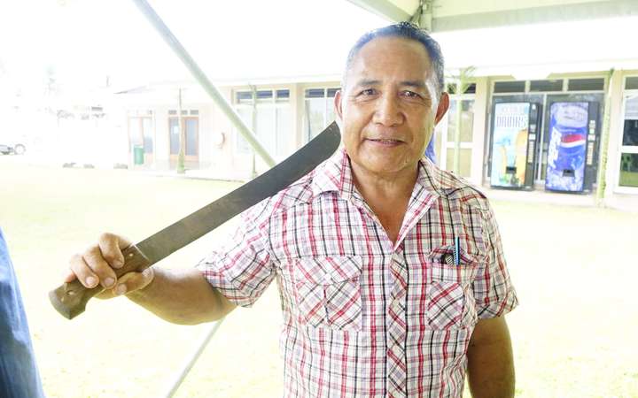Timothy Magaoa, a Niue master carver, with his preferred tool: a pelu, or machete. 