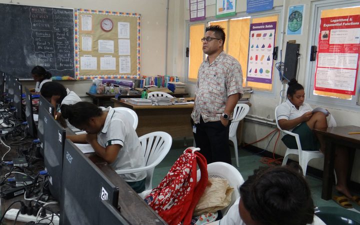 High school students in the Marshall Islands take the recent College of the Marshall Islands placement test under the watchful eye of proctor CMI official Terry Hazzard. 