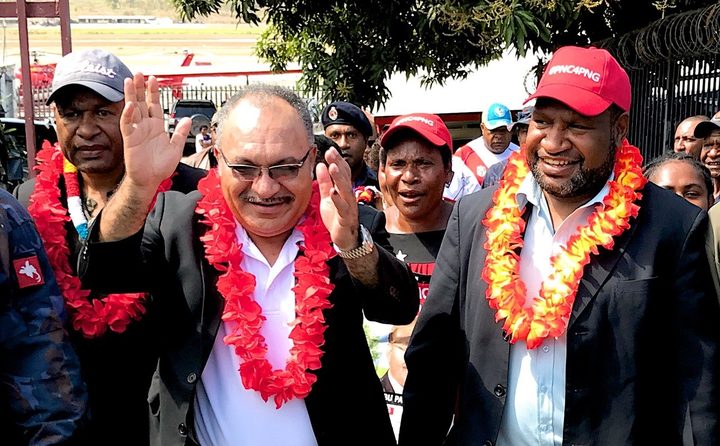 Papua New Guinea's prime minister Peter O'Neill  (with glasses) celebrates being declared winner of the election in his Ialibu-Pangia electorate, alongside fellow victorious People's National Congress member James Marape (red hat).