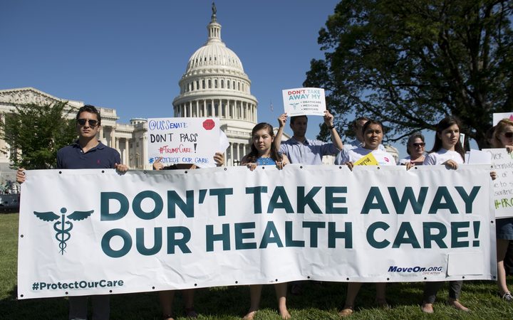 Protesters against the US Senate Republicans' healthcare bill holding a rally outside the US Capitol in June.