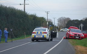 Police investigators at Kuranui Rd today and the two cars involved in the incident.
