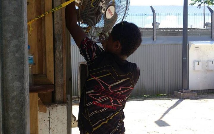 A Manus Islander taking a fan from the detention centre.