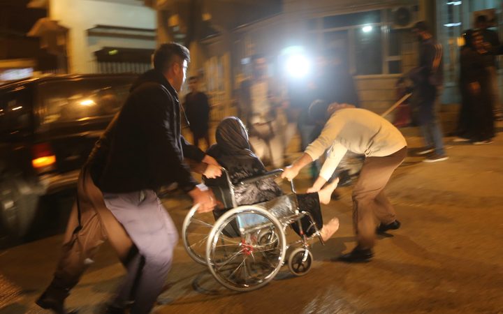 People carry a wounded person for treatment at Sulaymaniyah Hospital after a 7.2 magnitude earthquake hit northern Iraq