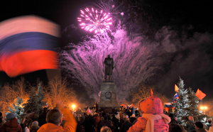 A man waves a Russian flag in Sevastopol as fireworks mark the incorporation of Crimea into the Russian federation.