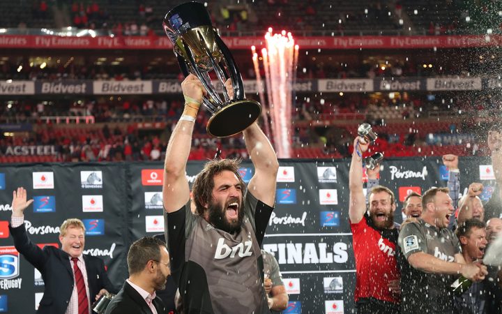 Crusaders captain Sam Whitelock holds the Super Rugby trophy aloft after their championship win last year.