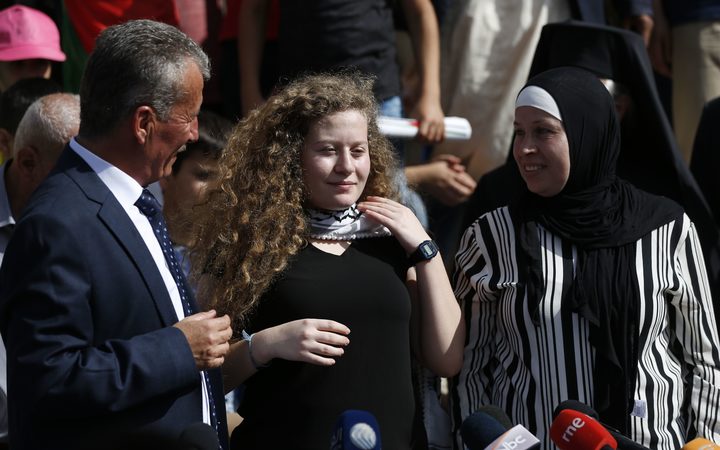 Palestinian activist and campaigner Ahed Tamimi, centre, with her father, left, and mother, right.