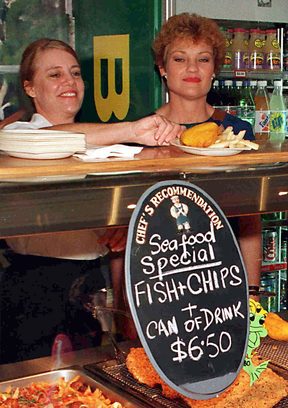 Anti-Asian MP Pauline Hanson (R) serves fish and chips at a shopping centre in Cairns 12 June as support for her One Nation party surges on the eve of the Queensland state elections. AFP PHOTO/Torsten BLACKWOOD (Photo by COURIER MAIL / AFP)