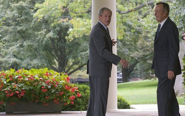 (FILES) In this file photo taken on September 25, 2008 US President George W. Bush (C)  walks out of the Oval Office with his father, former President George H. W. Bush,  at the White House in Washington, DC. (Photo by Jim WATSON / AFP)