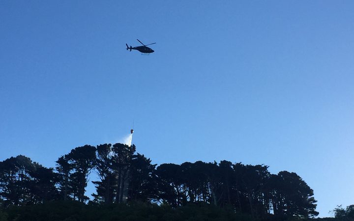 Helicopter putting out Wadestown fire with monsoon buckets