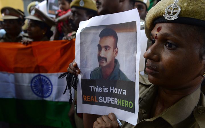 Indian security forces pose with the national flag and pictures of Indian Air Force pilot Abhinandan Varthaman during an event to pray for his return