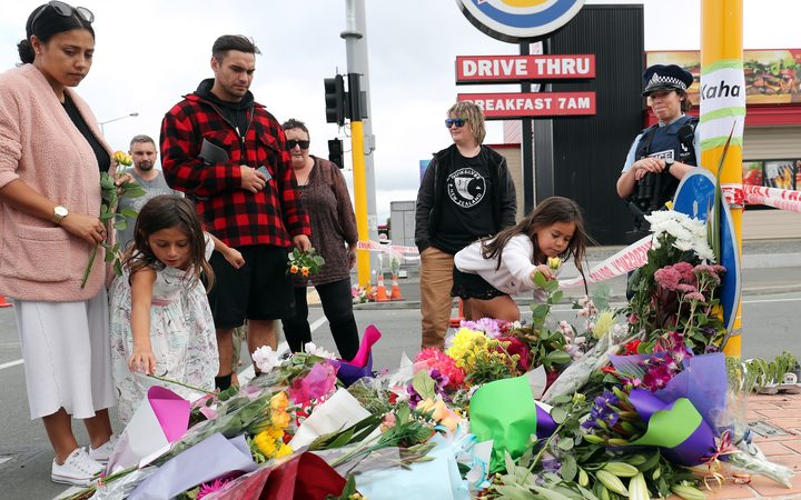 Residents place flowers at the police cordon near the Linwood Ave Mosque in Christchurch.