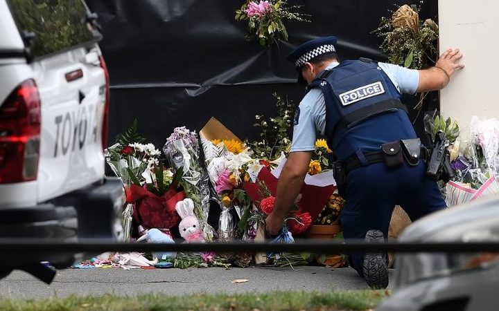 A police officer lays flowers at the Al Noor mosque.