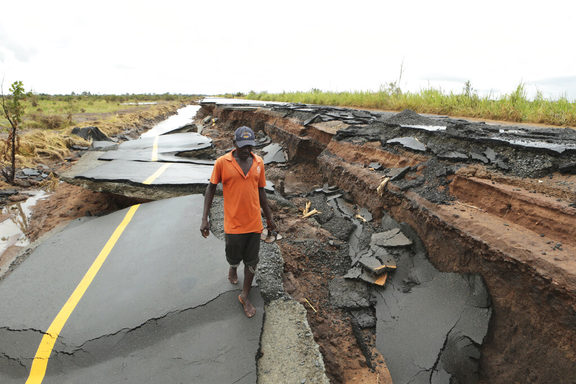 A man passes through a section of the road damaged by Cyclone Idai in Nhamatanda about 50 kilometres from Beira, in Mozambique, Friday March, 22, 2019. 