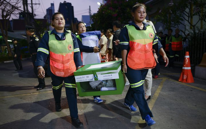 Thai workers and an electoral official carry a ballot box to storing after voting closed in the general election, at a polling station in Bangkok, Thailand, 24 March, 2019.
