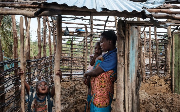 Ines Isaias, 21, takes a shelter from the rain with her children at her home which was destroyed by the winds of cyclone Idai in Beira, Mozambique, on 27 March, 2019.