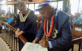 Chief Justice Yamase watches David Panuelo sign his Oath of Office.