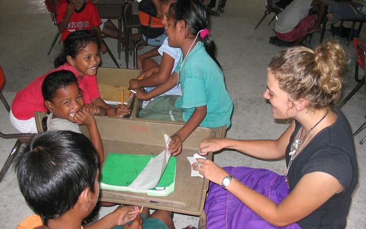 An American WorldTeach volunteer teacher works with students in a public school in Majuro
