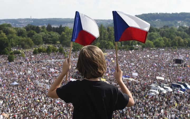 A boy holds Czech national flags during a rally in Prague demanding the resignation of Czech Prime Minister Andrej Babis, 23 June, 2019.