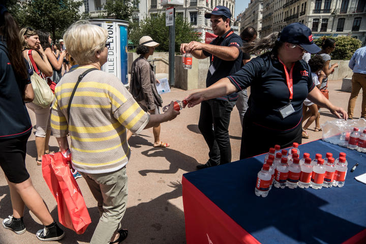 Volunteers from the Rapid Relief Team association distribute free water bottles on Place Bellecour in Lyon, France, on June 26, 2019 during the heat wave that is hitting France.