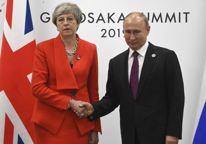 Russian President Vladimir Putin and British Prime Minister Theresa May shake hands during their meeting on the sidelines of the G20 summit in Osaka on June 28, 2019. (Photo by STR / POOL / AFP)