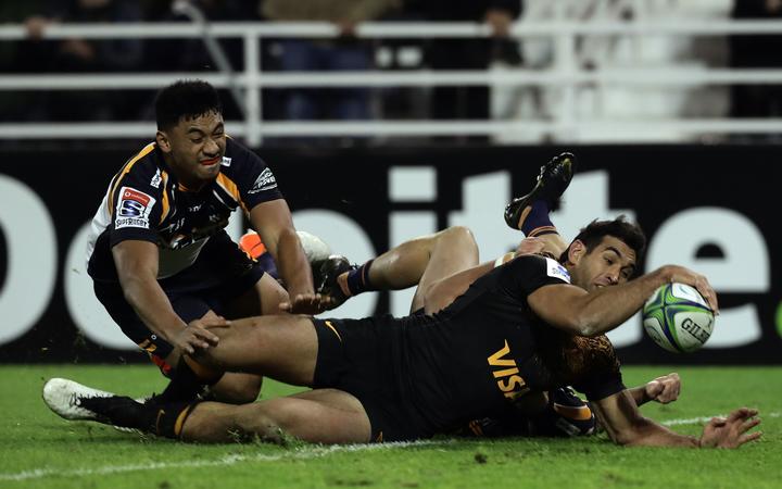 Argentina's Jaguares centre Matias Orlando (bottom-R) scores a try past Australia's Brumbies centre Irae Simone (L) and full back Thomas Banks during their Super Rugby semifinal match at Jose Amalfitani stadium in Buenos Aires