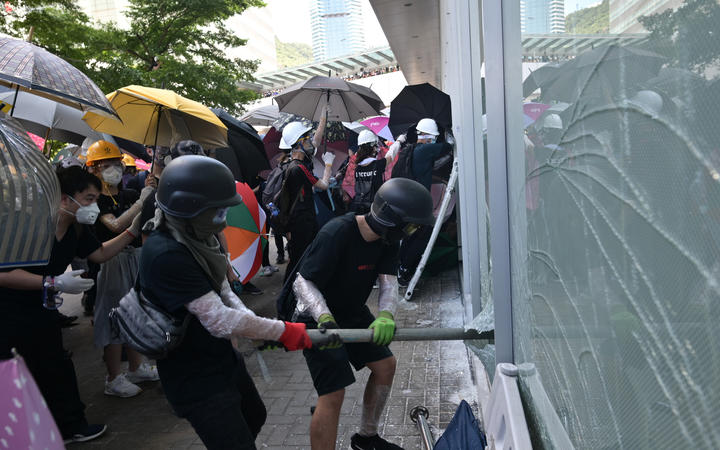 Protesters attempt to break a window at the government headquarters in Hong Kong. 