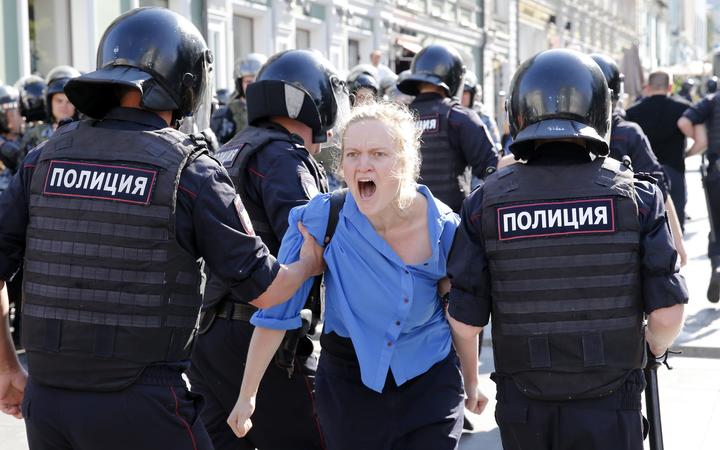 Police officers detain a protester during an unauthorised rally in downtown Moscow on July 27, 2019. 