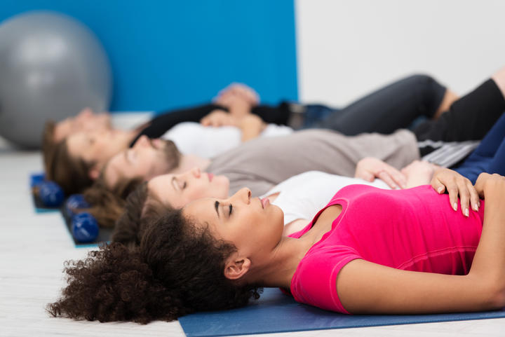 Aerobics class practising deep breathing for relaxation.