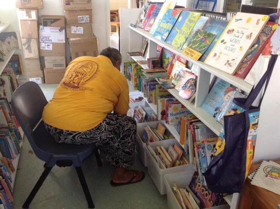 Local Tongan woman looking at books in library