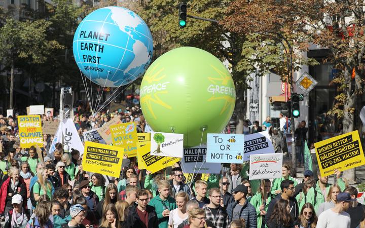 20 September 2019, North Rhine-Westphalia, Cologne: Participants of a demonstration walk through the streets with banners and balloons. The demonstrators follow the call of the movement Fridays for Future 