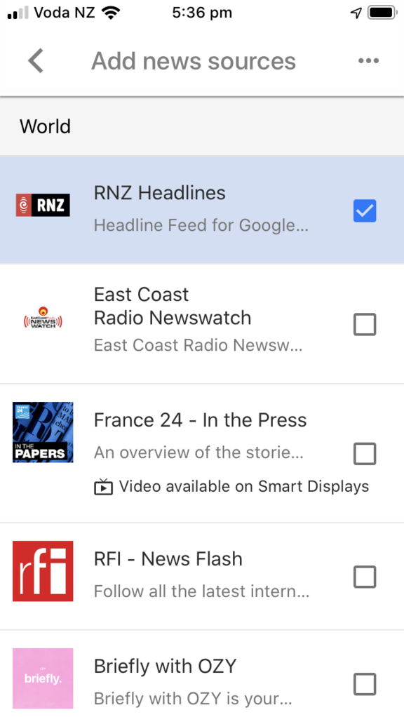 Google Assistant app news services 'Add news services' page, scrolled down to the World news section, with RNZ Headlines selected.