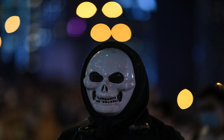 A protester looks on while wearing a mask at Admiralty area in Hong Kong on late October 4, 2019, as people hit the streets after the government announced a ban on facemasks.