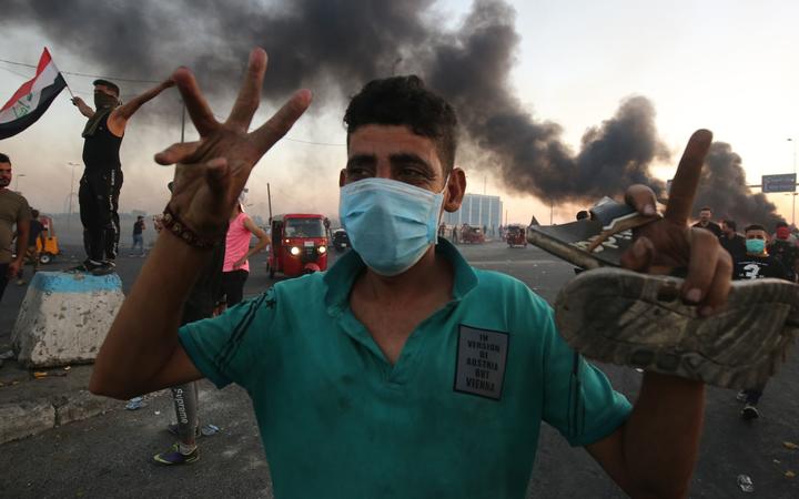 An Iraqi protester gestures during a demonstration against state corruption, failing public services, and unemployment, in the Iraqi capital Baghdad on October 5, 2019. )