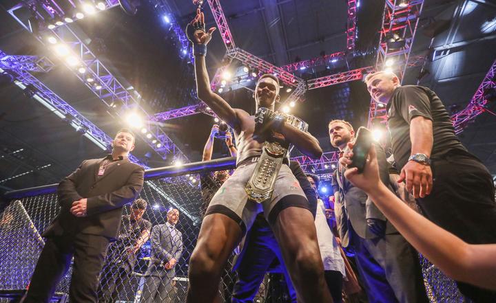 Israel Adesanya celebrates winning the UFC middleweight world title belt.