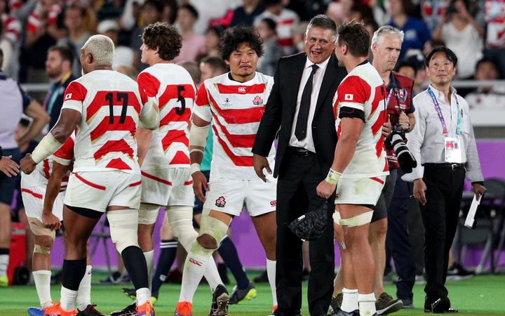 Japan players and coach Jamie Joseph celebrate their win over Scotland which qualified them for the RWC quarter-finals 2019