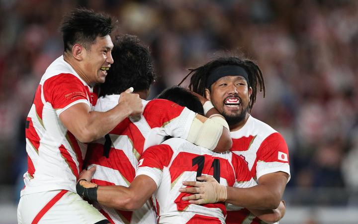 Japan rugby players celebrate their win over Scotland to qualify for RWC quarter-finals.

