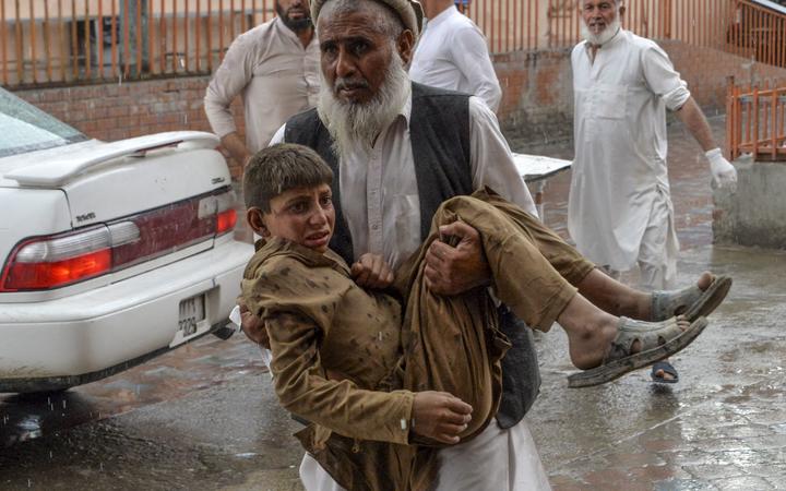 A volunteer carries an injured youth to hospital, following a bomb blast in Haska Mina district of Nangarhar Province on October 18, 2019. -