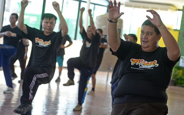 exercise programme at hospital in Bangkok. Dozens of sweaty cops exercise to pop songs as part of a scheme to reduce the number of overweight police in Bangkok.