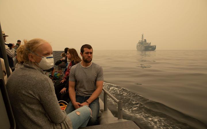 This handout photo taken on January 3, 2020 and released by the Royal Australian Navy shows people being evacuated from Mallacoota, Victoria state on a landing craft to MV Sycamore, during bushfire relief efforts.