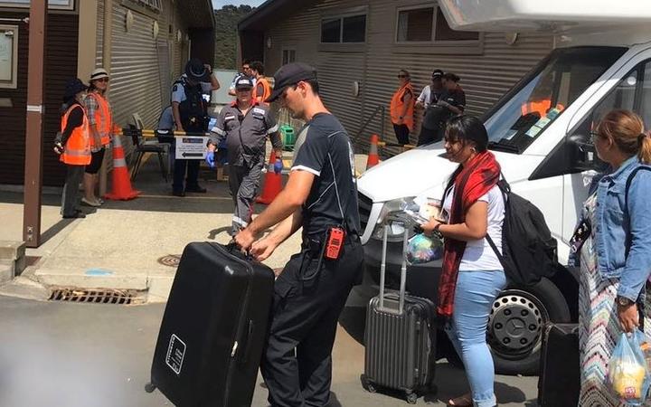 Evacuees prepare to leave the quarantine area at Whangaparāoa.